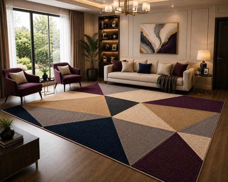 May include: A large rectangular area rug featuring a geometric pattern of triangles in shades of deep navy blue, dark plum, beige, tan, and gray. The rug has a textured, pile surface and is positioned on a wooden floor in a living room setting.