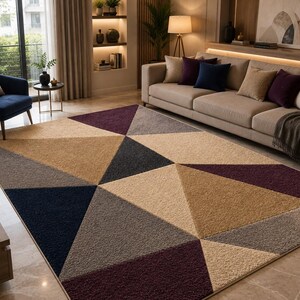 May include: A rectangular area rug featuring a geometric pattern of large triangles in shades of deep purple, navy blue, charcoal gray, and light beige. The rug has a textured, plush pile surface and covers a large portion of the floor space.