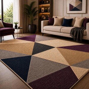 May include: A rectangular area rug featuring a geometric pattern of large triangles in shades of deep purple, navy blue, beige, and gray. The rug has a textured, pile surface and is finished with a clean, bound edge, covering a wooden floor.