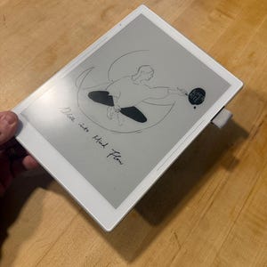May include: A white digital tablet with a gray screen displaying a line drawing of a person sitting inside a crescent shape, holding a pen. The text "SUPER NOTE" is inside a circle, and the phrase "Dive into Mind Flow" is written below.