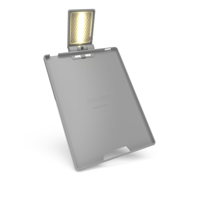 May include: A grey reading light with an integrated LED. The light is attached to a grey tablet-like device. The text "TOOLIGHT" is printed on the device. The LED light is rectangular and emits a warm, yellow glow.