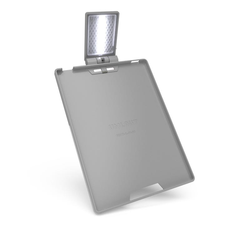 May include: A grey reading light with an integrated LED light panel. The light is attached to a grey tablet-shaped base. The text "TOOLIGHT" is printed on the base. The LED panel is rectangular and angled upwards.