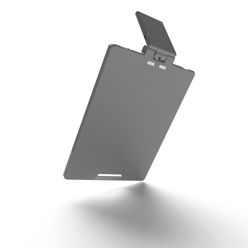 May include: A grey clipboard with a hinged top and a small, rectangular clip. The top section is angled upwards, and the clipboard casts a shadow on a white surface. The design is minimalist and modern.