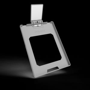 May include: A light gray rectangular frame with a hinged top flap and a large central cutout. The word UMLAUT is embossed on the upper portion of the frame. The structure is made of a solid material with a smooth finish and a functional hinge.