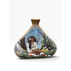 May include: A triangular ceramic vase featuring a relief illustration of a person with long dark hair wearing a white tunic, sitting in a grassy landscape with trees. The scene includes a small animal held in their lap and a blue sky background.