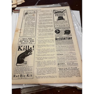 May include: A vintage page from The Literary Digest dated October 8, 1921, featuring black text and illustrations on aged paper. The content includes advertisements for Rat Bis-Kit, Cuticura Soap, and Packer's Duo-Radiant heaters, alongside a Current Events column.
