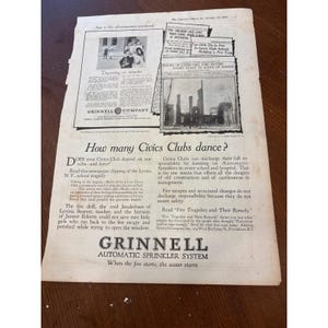 May include: A vintage black and white advertisement from The Literary Digest dated October 29, 1921, for the Grinnell Automatic Sprinkler System. The page features text, headlines about a school fire tragedy, and a photograph of a burned building.