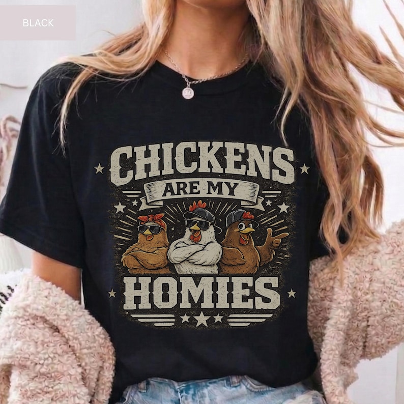 May include: Black t-shirt with the text "CHICKENS ARE MY HOMIES." The graphic features three chickens wearing sunglasses and hats. The chickens are brown and white. The text is in a distressed, vintage style.