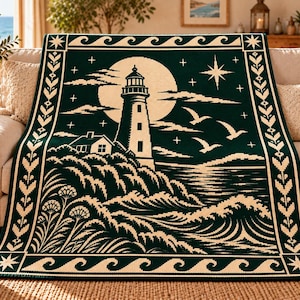 May include: A dark green and cream woven throw blanket featuring a lighthouse on a rocky cliff, a large full moon, flying seagulls, and crashing ocean waves. The design is framed by a decorative border with wave patterns and star motifs.