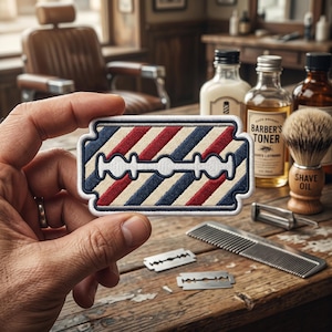 May include: A barber shop patch with a razor blade design. The patch features red, white, and blue stripes, with a white razor blade in the center. The patch is held in front of a barber shop scene with shaving supplies.