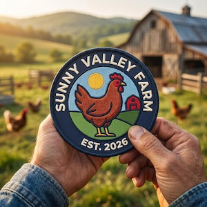 May include: A round, navy blue patch with the words "Sunny Valley Farm" encircling a brown chicken illustration, a red barn, and a yellow sun. The text "EST. 2026" is at the bottom. The patch is held in front of a farm scene.