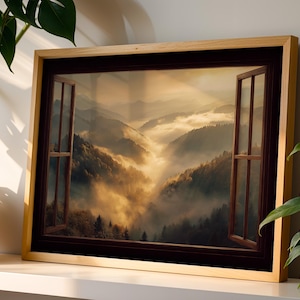 May include: A rectangular wall art print in a light wood frame depicting an open window view of a misty mountain valley at sunrise. The scene features golden light filtering through clouds over forested slopes, framed by dark brown window panes.