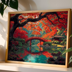 May include: A framed print of a Japanese garden scene. A red arched bridge spans a tranquil pond, reflecting the vibrant red and orange autumn foliage. A traditional building sits on the right, under a canopy of trees. The artwork is in a light wood frame.