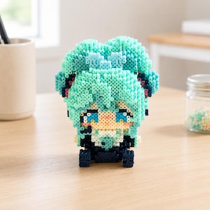 May include: A three-dimensional figurine constructed from small, cylindrical turquoise, dark blue, and peach-colored plastic beads. The figure features large, bright blue eyes, a peach-colored face, and voluminous turquoise hair styled in twin tails.