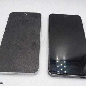 Può includere: Due smartphone neri sono mostrati affiancati. Uno ha un retro strutturato e opaco e una cornice argentata. L'altro ha uno schermo nero lucido e una cornice argentata. Entrambi i telefoni hanno una piccola apertura per la fotocamera nella parte superiore.