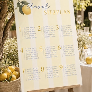 Könnte beinhalten: Ein Hochzeits-Sitzplan auf einer Staffelei. Das Schild hat einen gelb-weiß gestreiften Hintergrund mit den Worten "Unser Sitzplan" oben. Jeder Abschnitt listet Namen auf, mit Zitronen und Blättern als Dekoration.