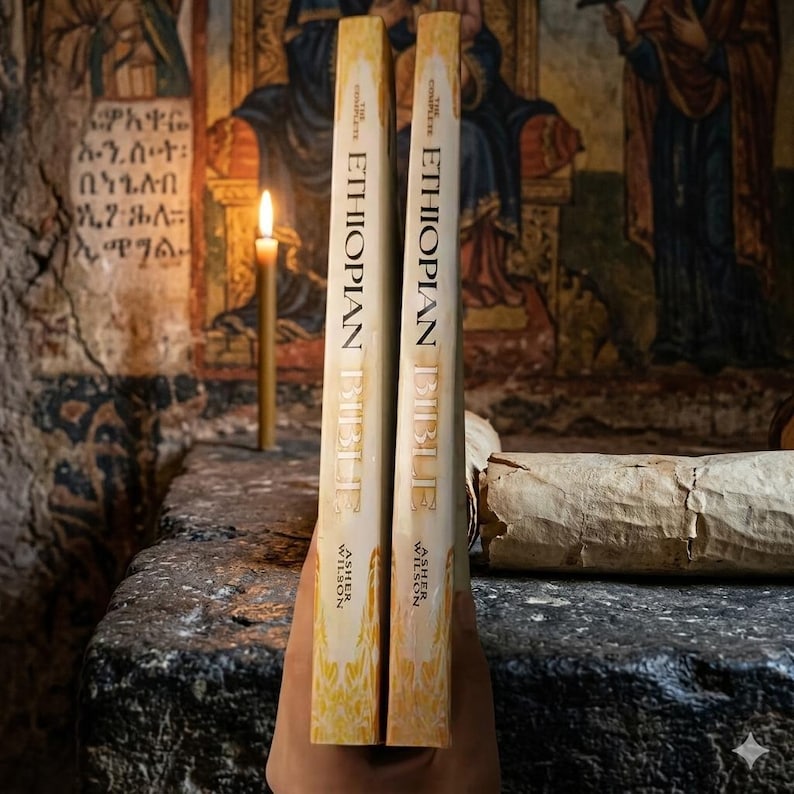 K&ouml;nnte beinhalten: Zwei Exemplare von "The Complete Ethiopian Bible" von Asher Wilson werden aufrecht gehalten. Die B&uuml;cher haben einen cremefarbenen Einband mit goldfarbenen Buchstaben. Eine brennende Kerze und eine Schriftrolle befinden sich im Hintergrund auf einer Steinoberfl&auml;che.