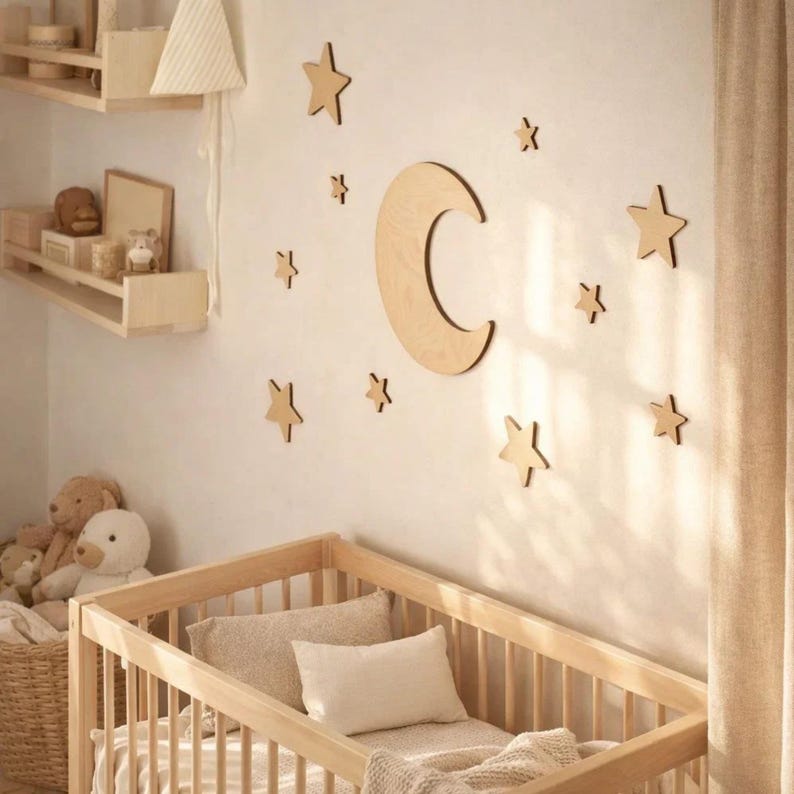 May include: A nursery scene featuring a wooden crib with bedding, a wall decorated with wooden stars and a crescent moon, and a shelf with decorative items. The room has a neutral color palette with natural wood tones.