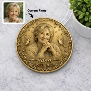 May include: A bronze-colored memorial coin with a portrait of a woman, the word "mom", and the years 1953-2025. The coin features decorative elements including stars and birds, and the text "Custom Photo".