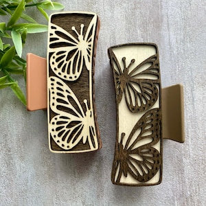 May include: A white ceramic mug with a black handle and the text "But First, Coffee" in a bold, black font. The mug is set against a blurred background, suggesting a cosy setting.