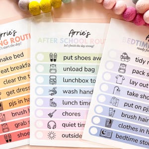 May include: Three laminated routine charts titled Arrie's Morning Routine, After School Routine, and Bedtime Routine. Each chart features colorful horizontal rows with icons and text for daily tasks, including checkboxes for tracking progress.