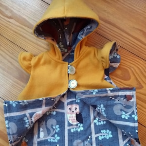 Gold colored pixie vest with a warm woodland animal print flannel lining. Button closure and flutter sleeve caps.