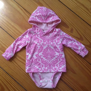 Pink Baby Hoodie in a damask style print 100% cotton fabric. Double layer with long sleeves.