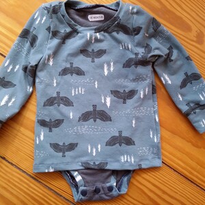 100% cotton teal blue shirt with a bird print, handmade in jersey knit with a gray bodysuit underneath.