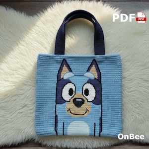 May include: A light blue crochet tote bag featuring a cartoon dog face. The bag has dark blue handles and a matching dog face design. The text "PDF" and "OnBee" are visible on the bag.