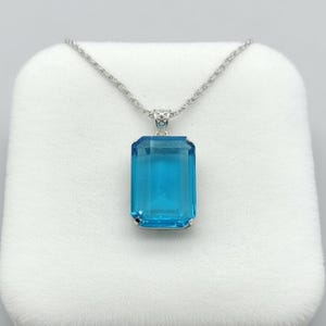Deep sky blue topaz crystal emerald cut pendant in sterling silver, elegant fine jewelry necklace designed for engagement gift, bridal jewelry or wedding accessory.