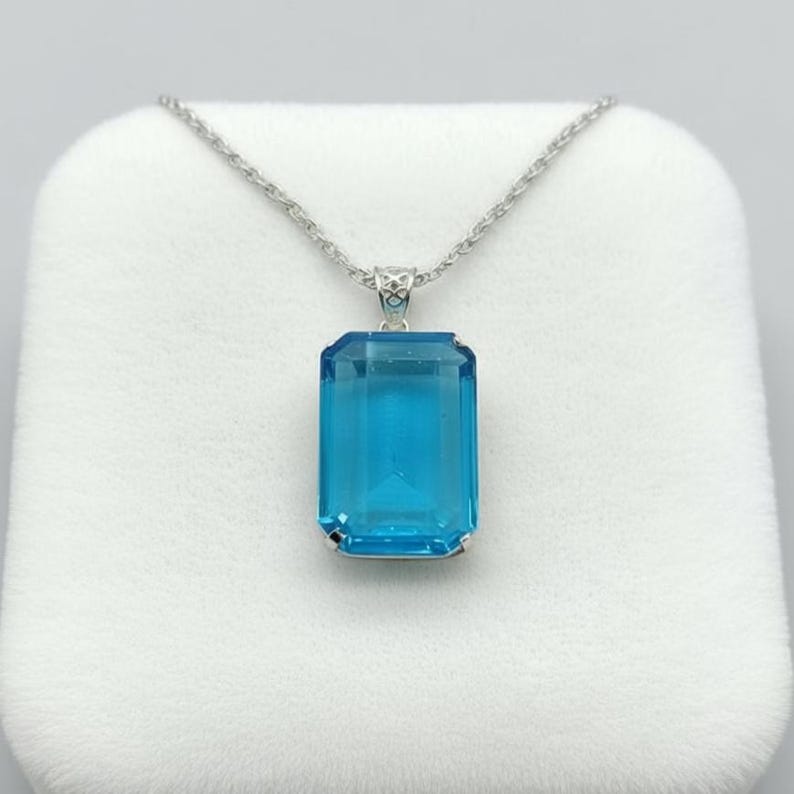 Deep sky blue topaz crystal emerald cut pendant in sterling silver, elegant fine jewelry necklace designed for engagement gift, bridal jewelry or wedding accessory.