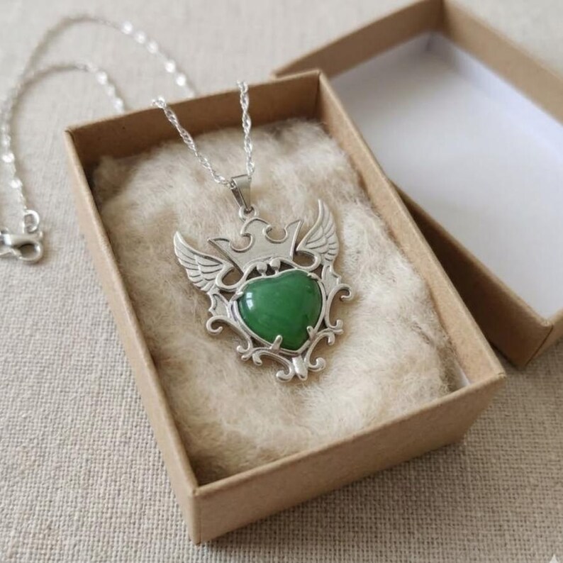 Certified green aventurine pendant with smooth polished finish and decorative silver wings, unique artisan crystal necklace.