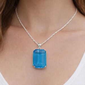 Elegant emerald cut blue topaz gemstone pendant in polished sterling silver, luxury statement necklace ideal for December birthstone gift, anniversary present or birthday jewelry for her.