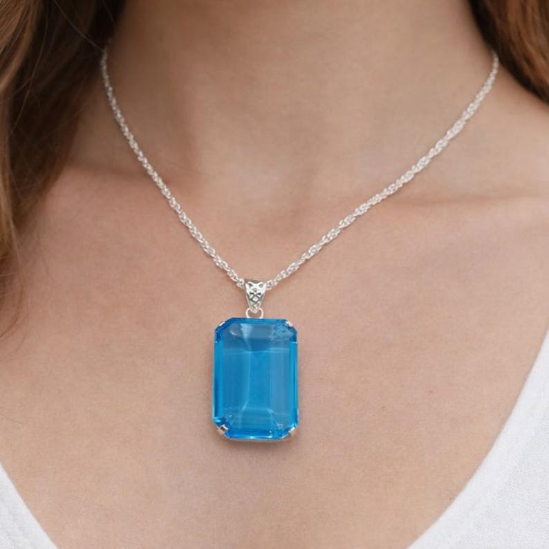 Elegant emerald cut blue topaz gemstone pendant in polished sterling silver, luxury statement necklace ideal for December birthstone gift, anniversary present or birthday jewelry for her.