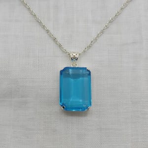 Swiss blue emerald shape topaz gemstone necklace with high polish silver finish, statement jewelry piece for women ideal for office wear and formal occasions.
