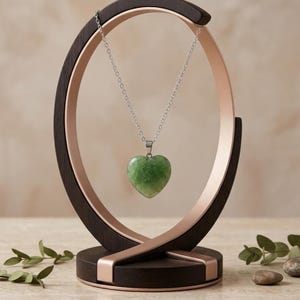 Green fluorite healing crystal heart pendant showcasing soft translucent green color in elegant silver setting.