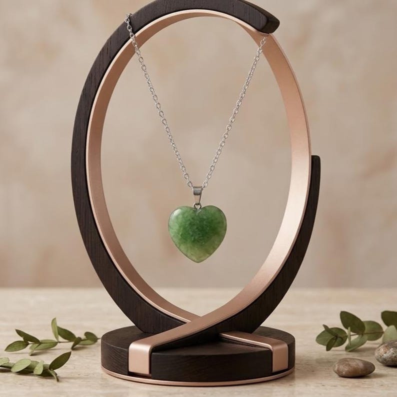 Green fluorite healing crystal heart pendant showcasing soft translucent green color in elegant silver setting.