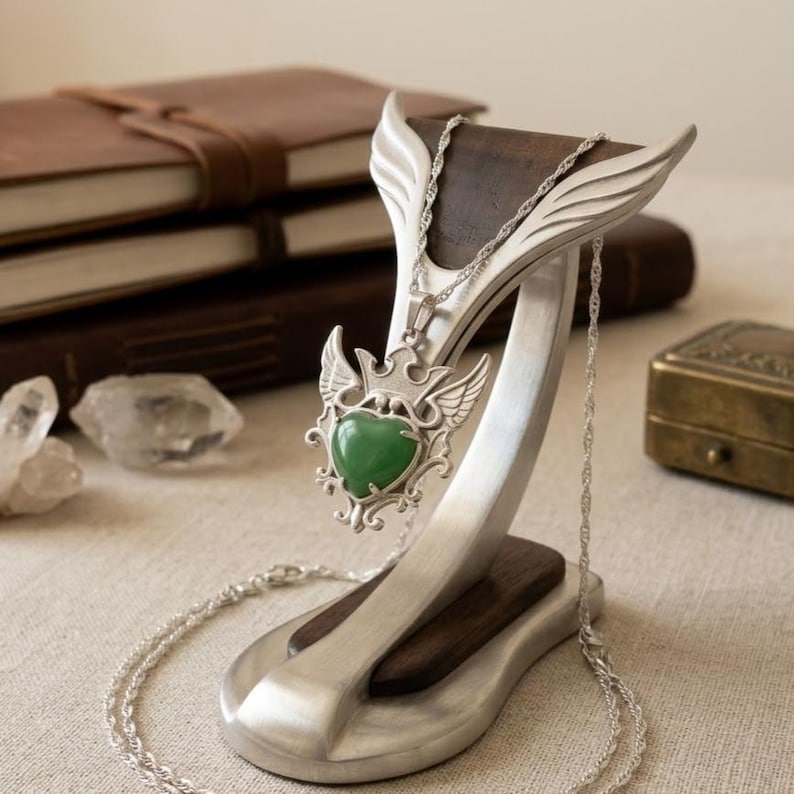 Green aventurine healing crystal pendant featuring polished heart stone and vintage inspired sterling silver setting.