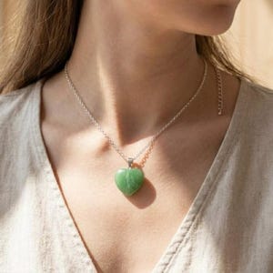Handmade certified green fluorite crystal heart pendant in silver setting designed as heart chakra healing jewelry.