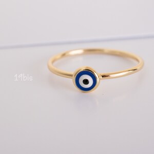 Peut inclure: Une bague en or avec un charme &oelig;il bleu et blanc. La bague est une bande simple avec un petit charme rond au centre.