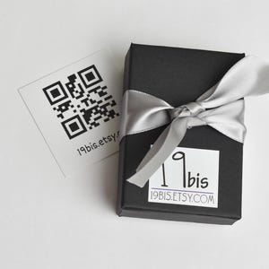 Peut inclure: Une bo&icirc;te cadeau noire avec un ruban argent&eacute; et une &eacute;tiquette blanche avec le texte "19bis.etsy.com" et un code QR. La bo&icirc;te est sur une surface blanche.