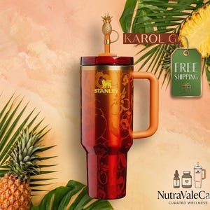 Pode incluir: Um copo Stanley vermelho e laranja com um design floral e uma al&ccedil;a. O copo tem uma tampa de palha em forma de abacaxi. A palavra "STANLEY" &eacute; vis&iacute;vel no copo. O fundo inclui um abacaxi e folhas de palmeira.