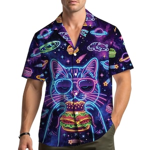 Puede incluir: Camisa de manga corta con un diseño temático espacial. Presenta un gato de neón con gafas de sol comiendo una hamburguesa, rodeado de planetas, estrellas y hamburguesas. La paleta de colores incluye morado, azul y rosa. La camisa tiene cuello abotonado.
