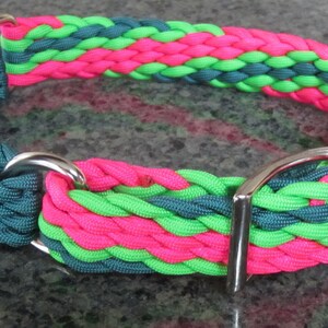 Puede incluir: Un collar para perros vibrante con un dise&ntilde;o trenzado en verde azulado, rosa ne&oacute;n y verde lima. El collar tiene una hebilla y anillas en D de metal plateado. Los colores brillantes crean un accesorio llamativo.
