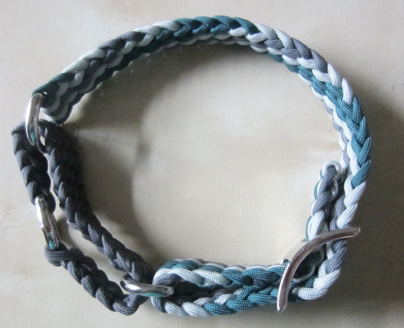Puede incluir: Collar trenzado para perros en tonos grises, turquesa y blanco. El collar presenta un dise&ntilde;o tejido con herrajes met&aacute;licos plateados. El collar est&aacute; dise&ntilde;ado para un perro de tama&ntilde;o mediano.