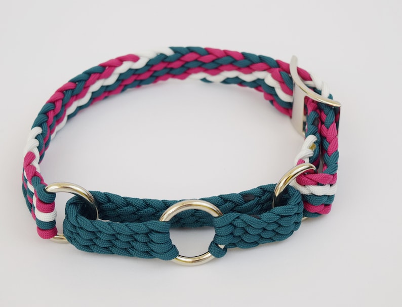 Puede incluir: Un collar trenzado para perros en color teal, blanco y magenta. El collar presenta una hebilla de metal plateado y dos anillos de metal plateado. El collar est&aacute; dise&ntilde;ado con un patr&oacute;n trenzado y es adecuado para mascotas.