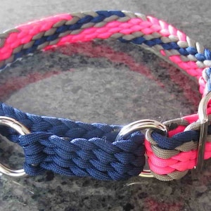 Puede incluir: Collar trenzado para perros con una combinaci&oacute;n de colores vibrantes. El collar presenta una combinaci&oacute;n de hebras tejidas rosas, grises y azul marino. Tiene herrajes met&aacute;licos plateados, incluidos anillos en D y una hebilla. Este accesorio est&aacute; dise&ntilde;ado para mascotas.