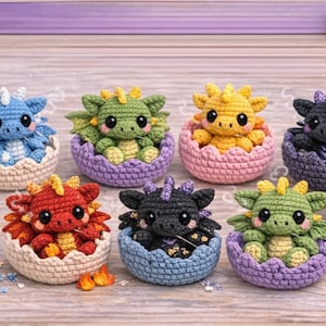 May include: A collection of seven crocheted baby dragons in various colors, each nestled in a matching eggshell. The dragons are blue, green, yellow, black, and red, with detailed wings and horns. The eggshells are approximately 2 inches in diameter.