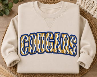 Cougars PNG, Royal Blue Gold Cougars PNG, Maskottchen-Design im Strick-Look, Cougars-Spieltagsshirt, Schulgeist-PNG