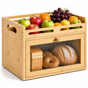 May include: A rectangular bamboo bread box with a drop-down door featuring a fluted glass panel. The top surface holds a variety of fresh fruit including red apples, green apples, oranges, and a cluster of dark purple grapes.